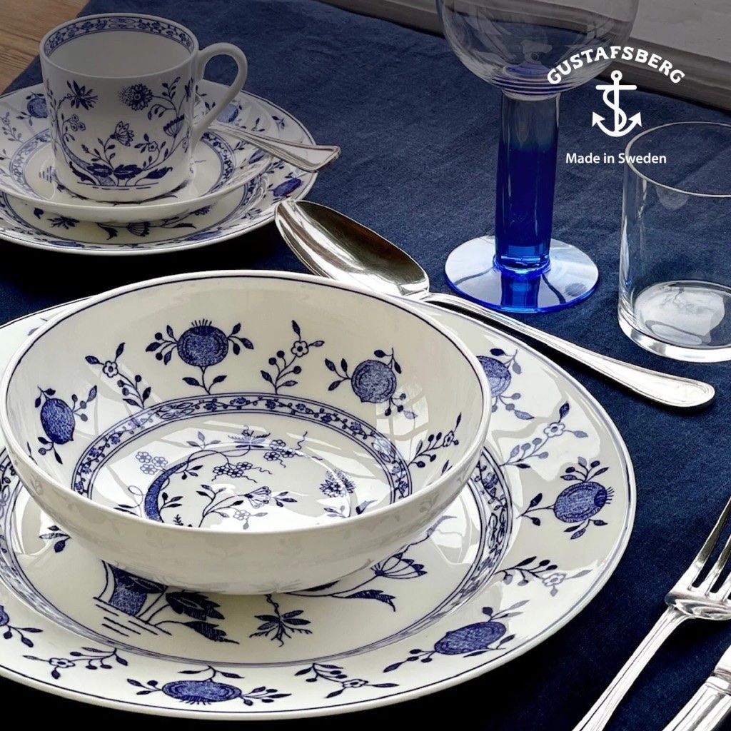 Gustafsberg blue-and-white porcelain place setting on a navy tablecloth.